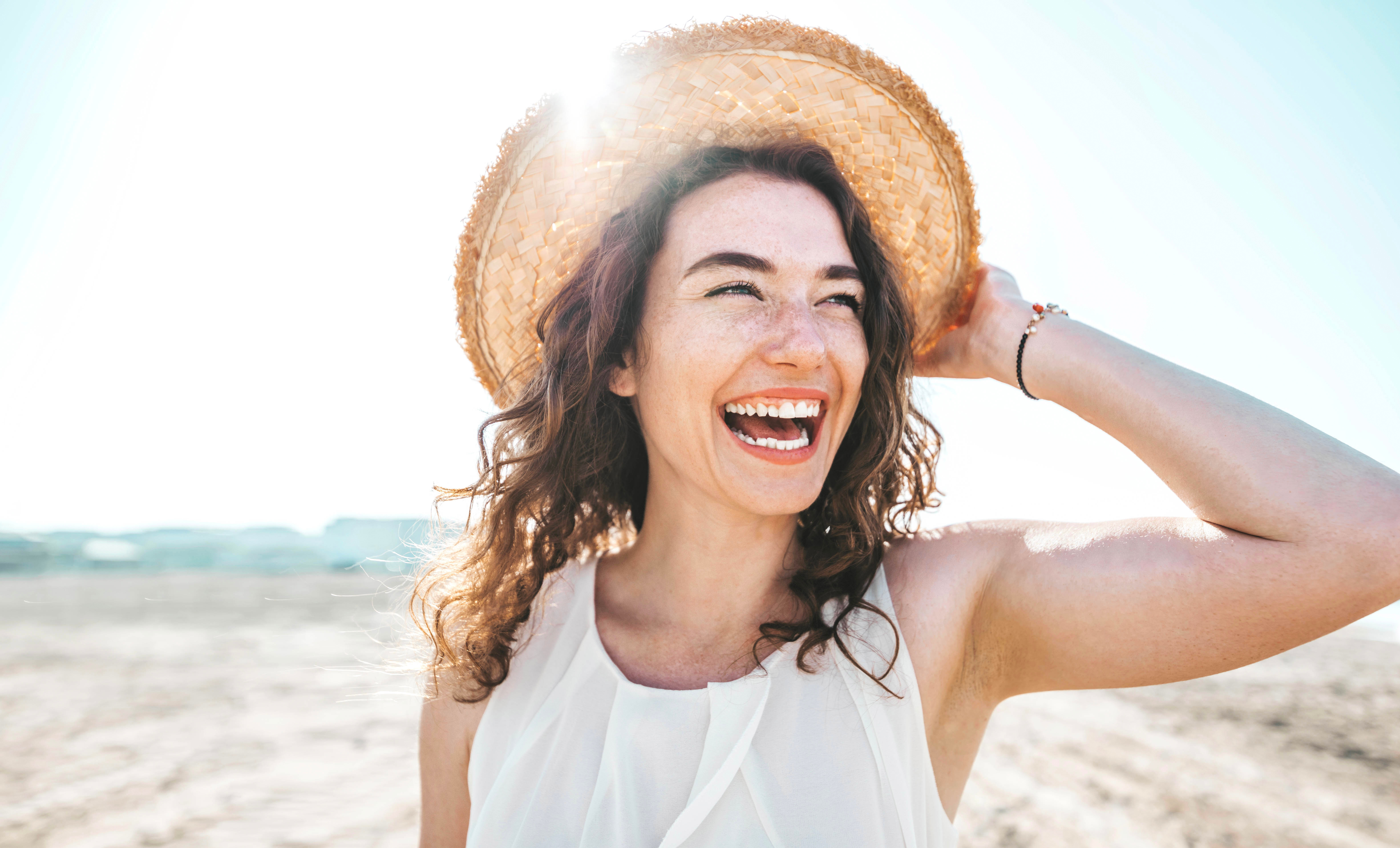 Happy beautiful young woman smiling at the beach side – Delightf